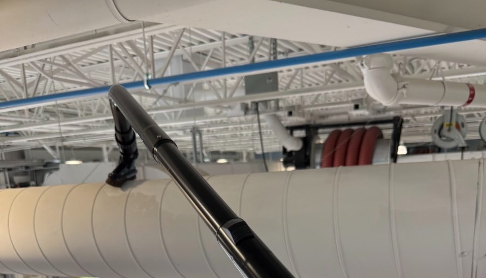 Dépoussiérage d'un conduit de ventilation en hauteur avec perche et aspirateur